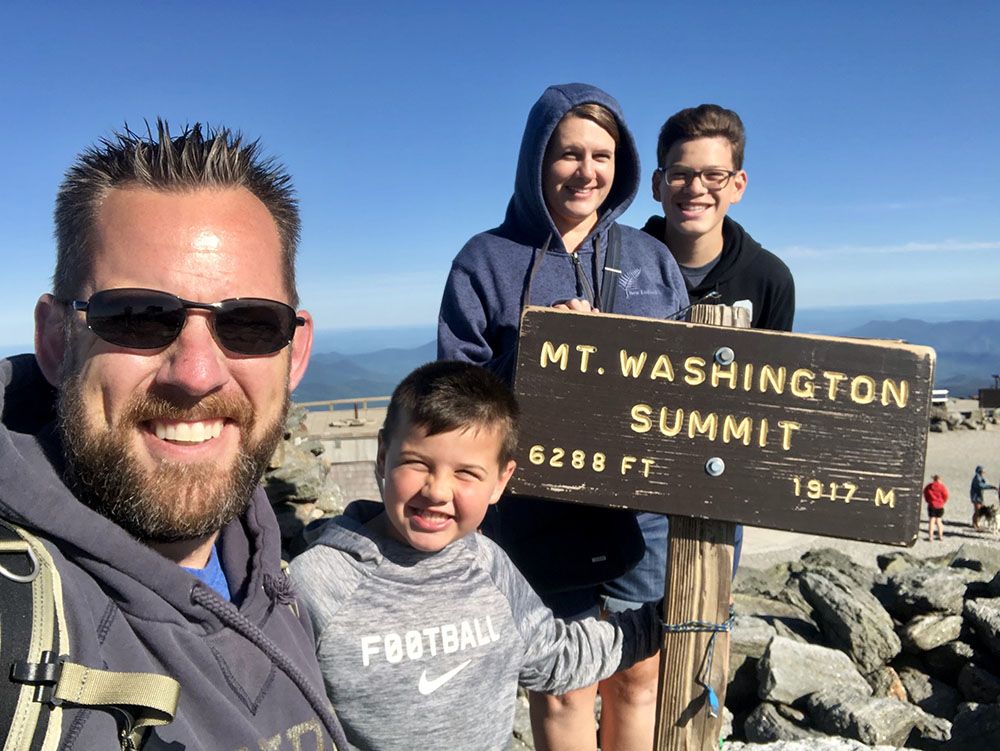 family standing on mount washington